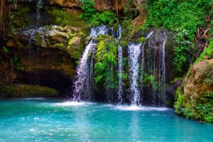 Ngare Ndare Forest waterfall cascading into a turquoise pool surrounded by lush indigenous forest in Laikipia, Kenya